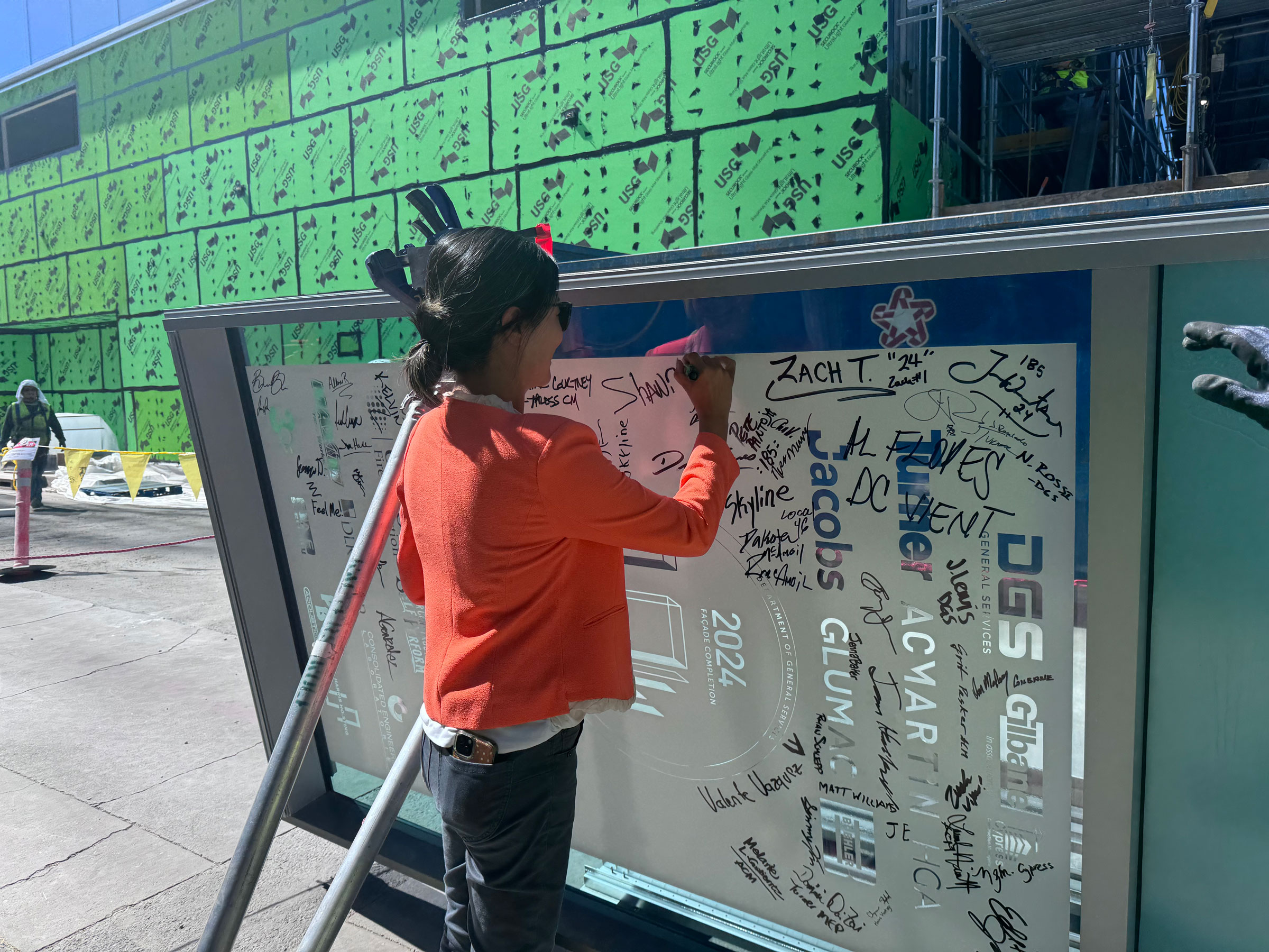 Project Executive, Wendy MacLeod, signs her name on the final panel.